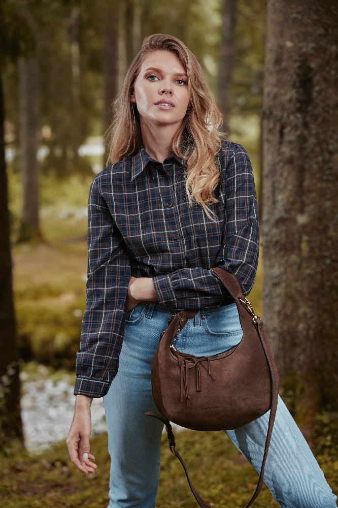 geantă maro din piele întoarsă purtată cu blugi și cămașă în carouri